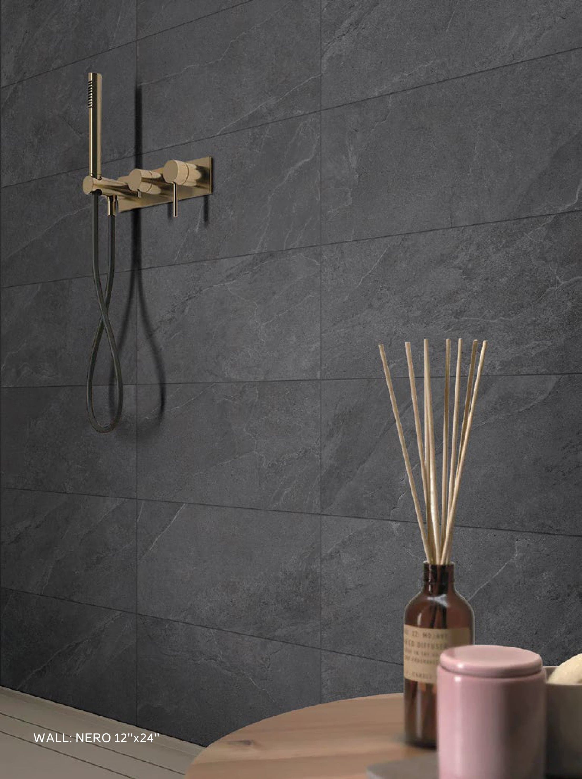 MOTLEY Nero tiled wall behind a brushed-gold shower fitting
